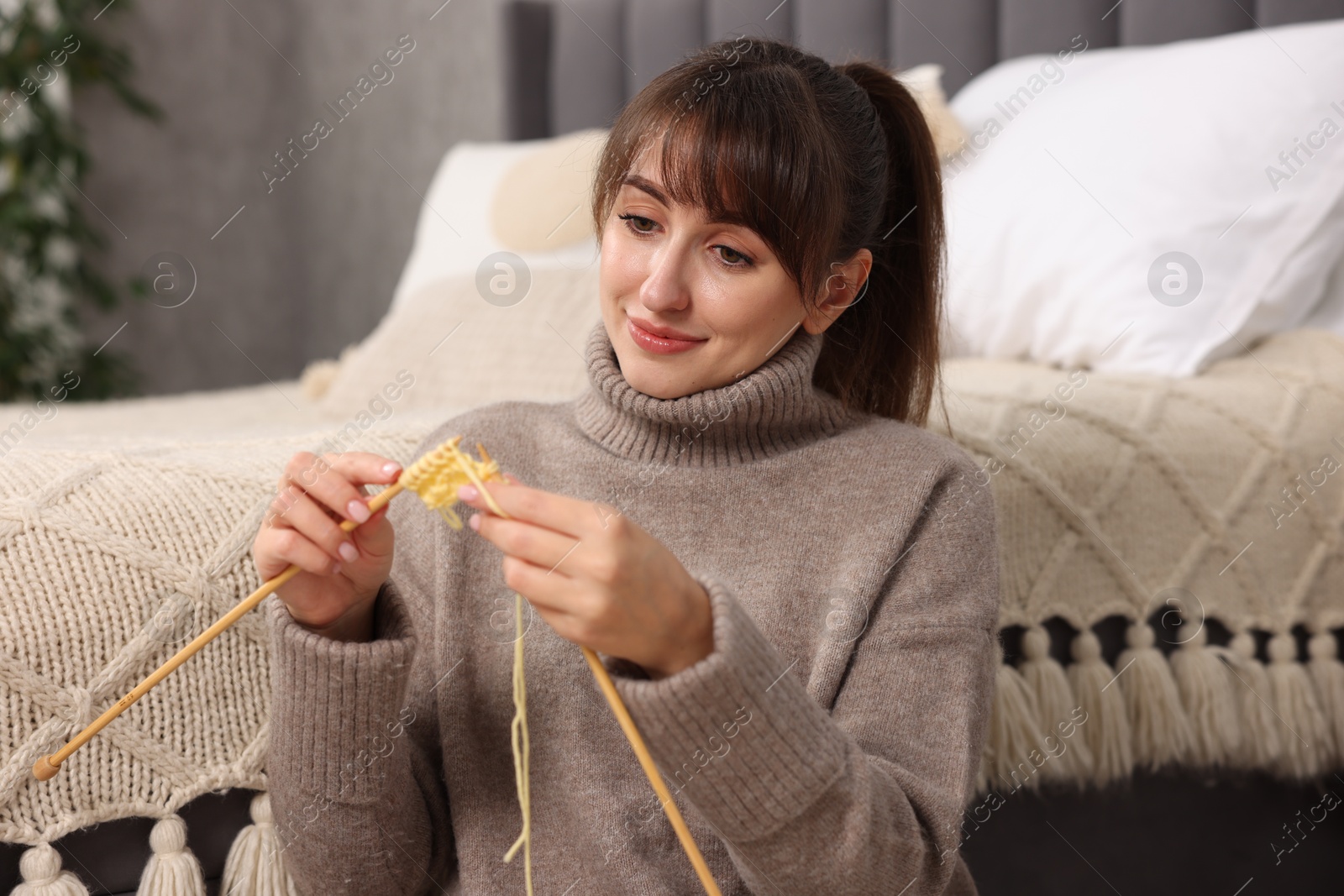 Photo of Beautiful woman knitting with needles at home