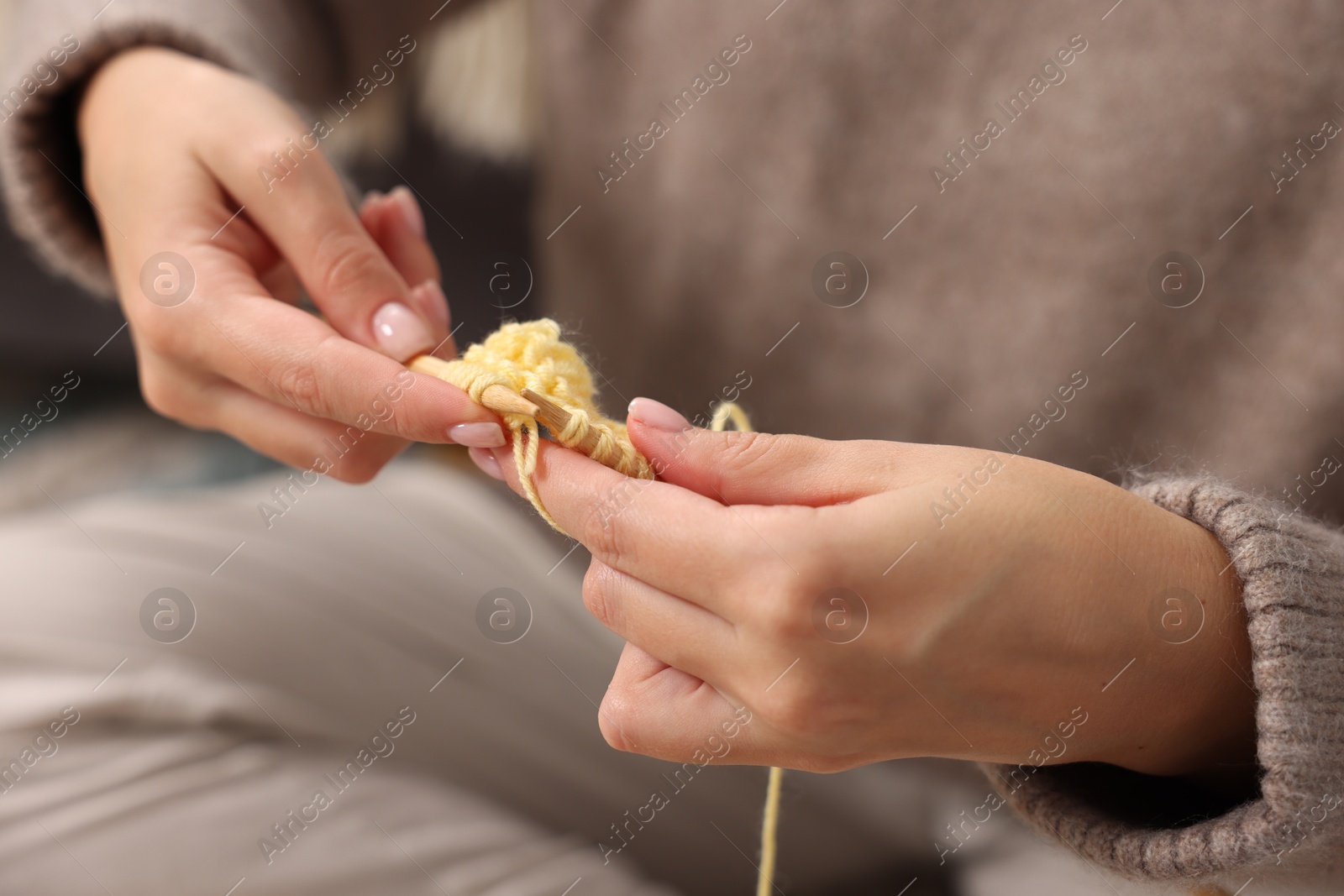 Photo of Woman knitting with needles at home, closeup