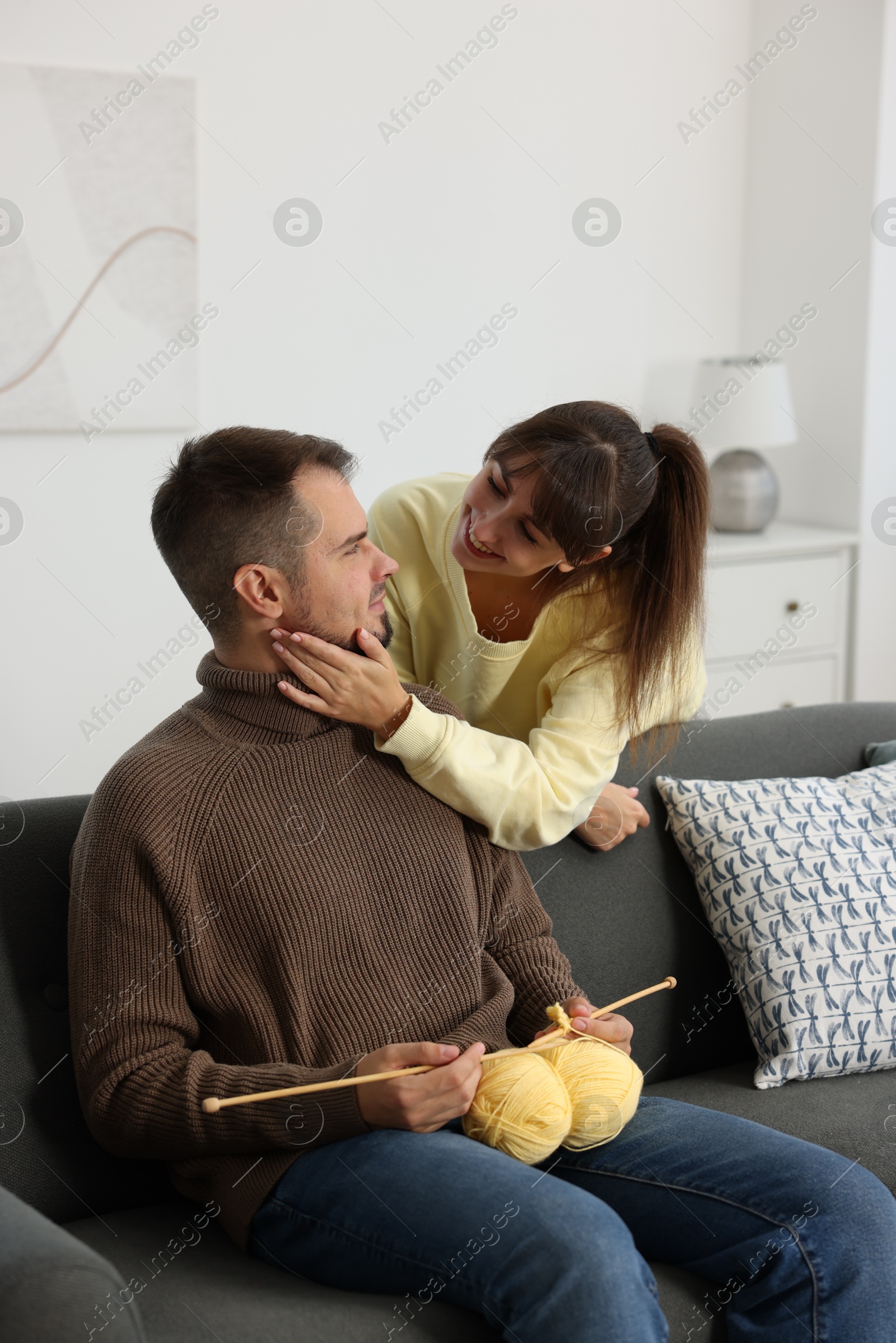 Photo of Woman teaching her boyfriend how to knit at home