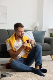 Man knitting with needles on floor at home