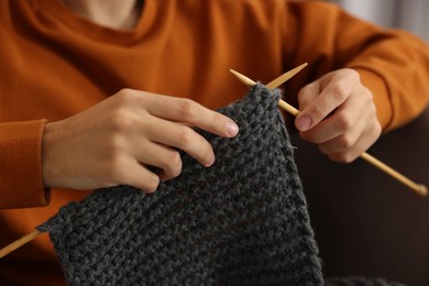 Man knitting with needles at home, closeup