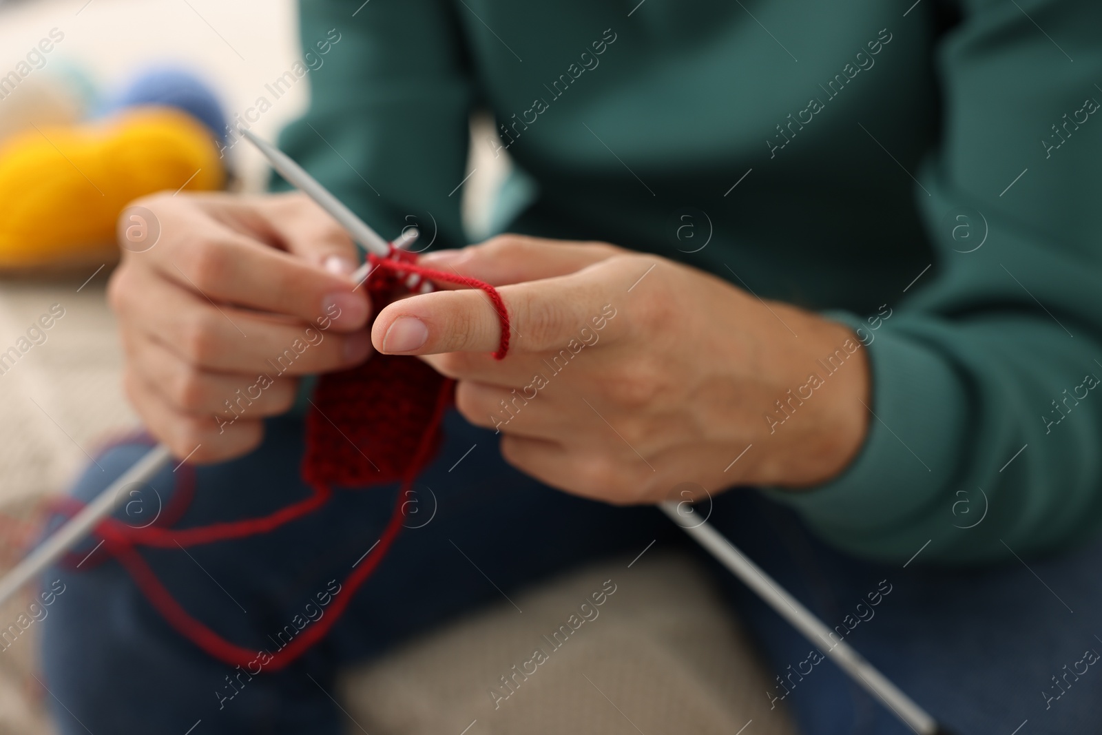 Photo of Man knitting with needles at home, closeup