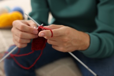 Man knitting with needles at home, closeup