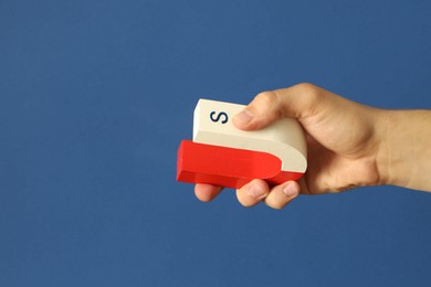 Photo of Man holding horseshoe magnet on blue background, closeup. Space for text