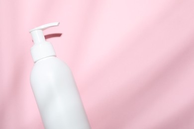 Shampoo in bottle on pink background, top view. Space for text