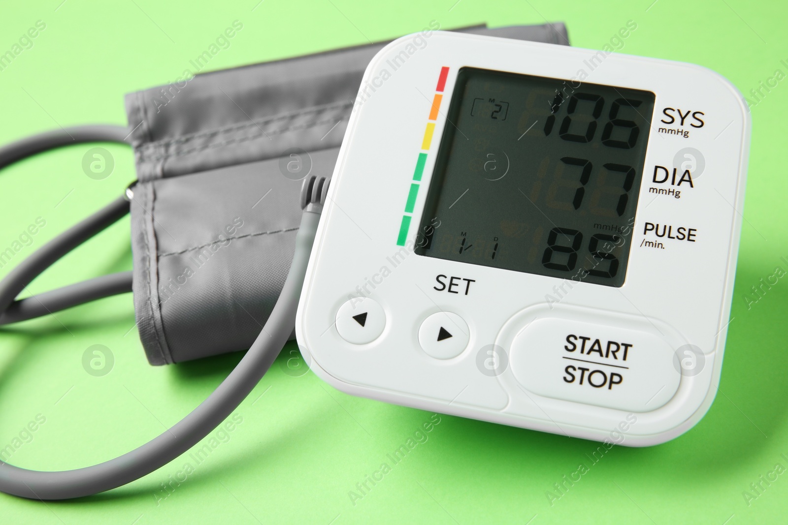 Photo of Blood pressure measuring device on green background, closeup