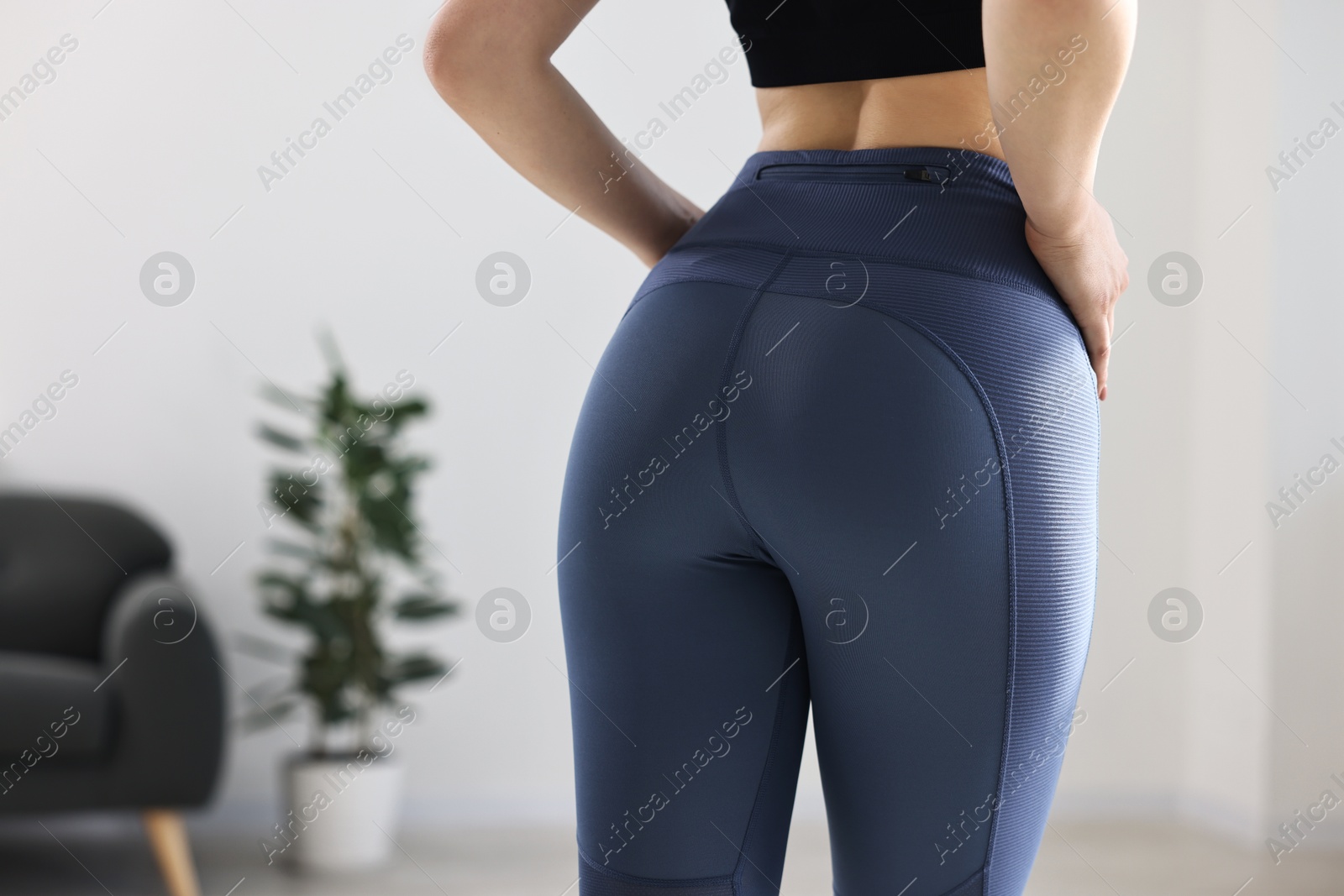 Photo of Woman wearing blue sports leggings indoors, closeup