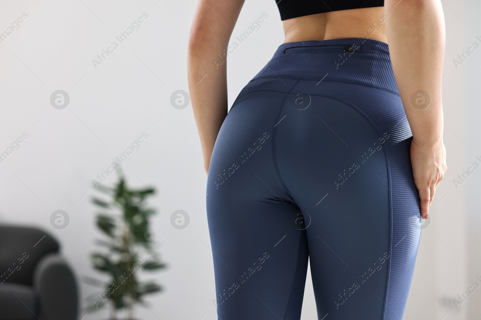 Photo of Woman wearing blue sports leggings indoors, closeup