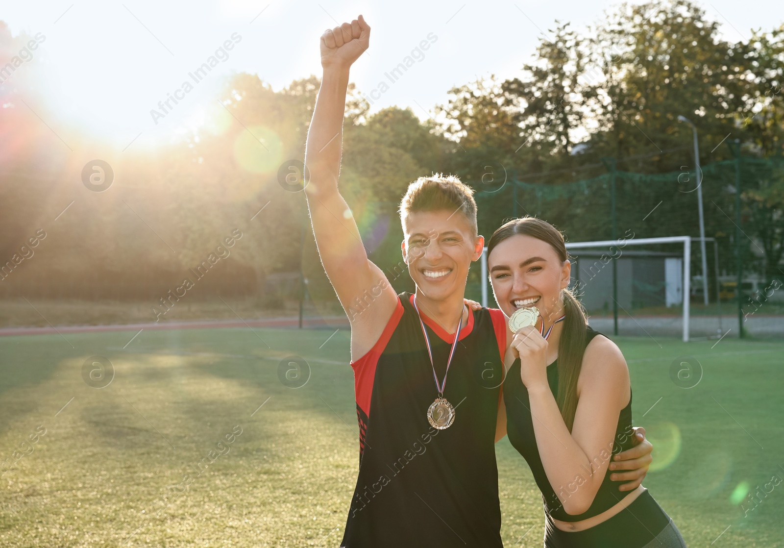 Photo of Portrait of happy winners with medals at stadium on sunny day. Space for text