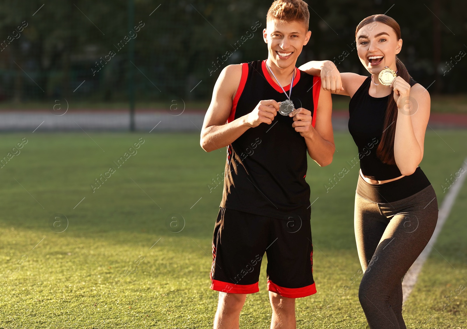 Photo of Happy winners with medals at stadium on sunny day. Space for text