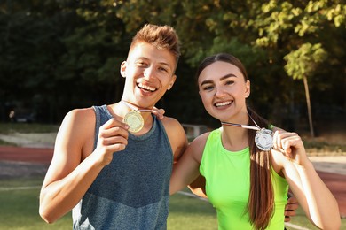 Photo of Two happy winners with medals at stadium