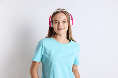 Photo of Portrait of teenage girl in headphones on white background