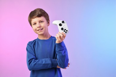 Photo of Happy little boy with controller on color background