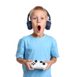 Emotional little boy in headphones playing video game with controller on white background