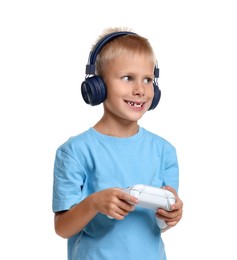 Photo of Happy little boy in headphones playing video game with controller on white background