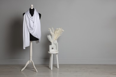 Photo of Female mannequin with white scarf indoors, space for text