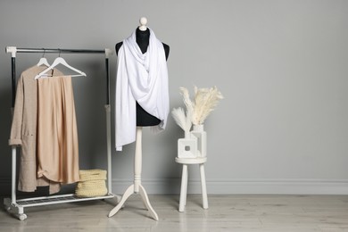 Photo of Female mannequin with white scarf and other clothes indoors