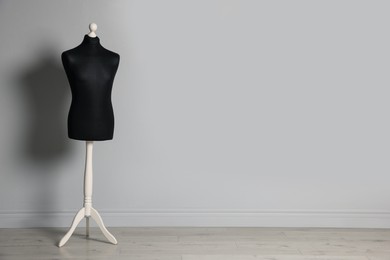 Photo of Black mannequin indoors, space for text. Fashion designer`s equipment