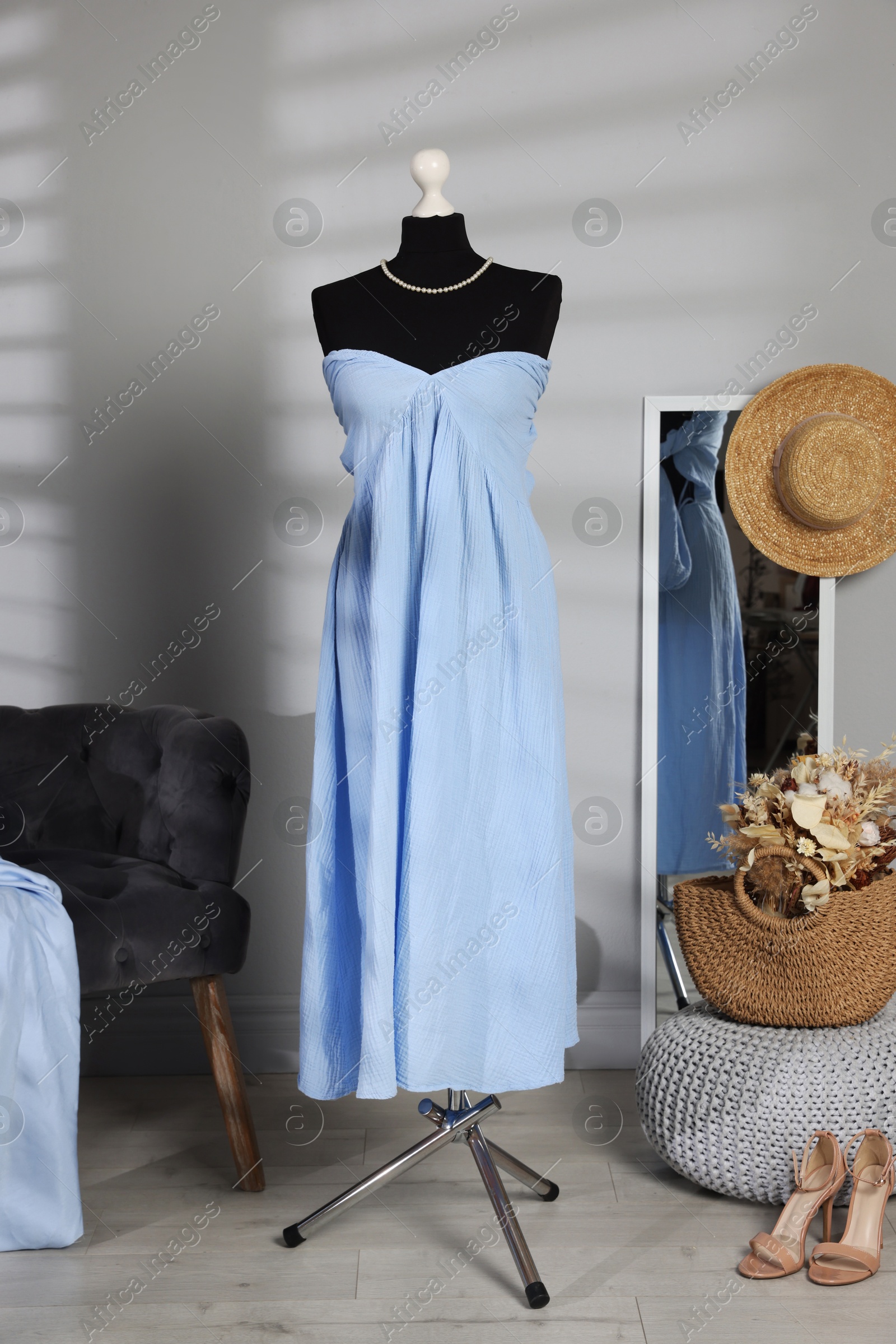 Photo of Female mannequin with stylish light blue dress and other clothes indoors