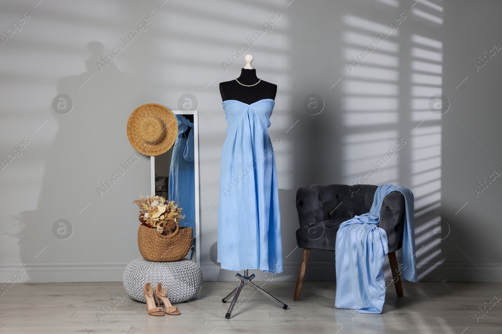 Photo of Female mannequin with stylish light blue dress and other clothes indoors