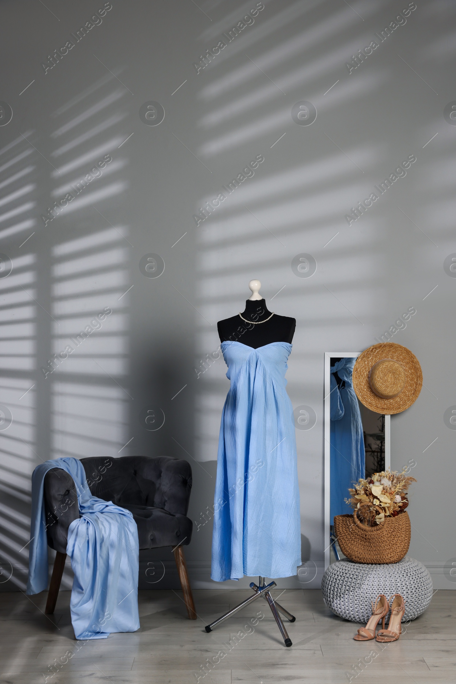 Photo of Female mannequin with stylish light blue dress and other clothes indoors