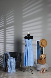 Photo of Female mannequin with stylish light blue dress and other clothes indoors