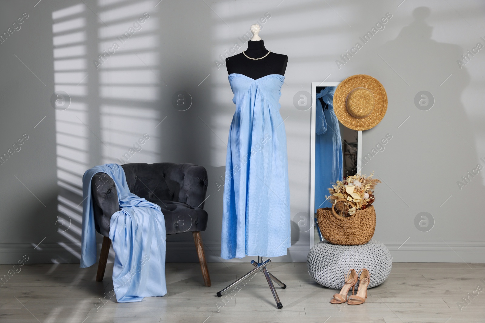 Photo of Female mannequin with stylish light blue dress and other clothes indoors