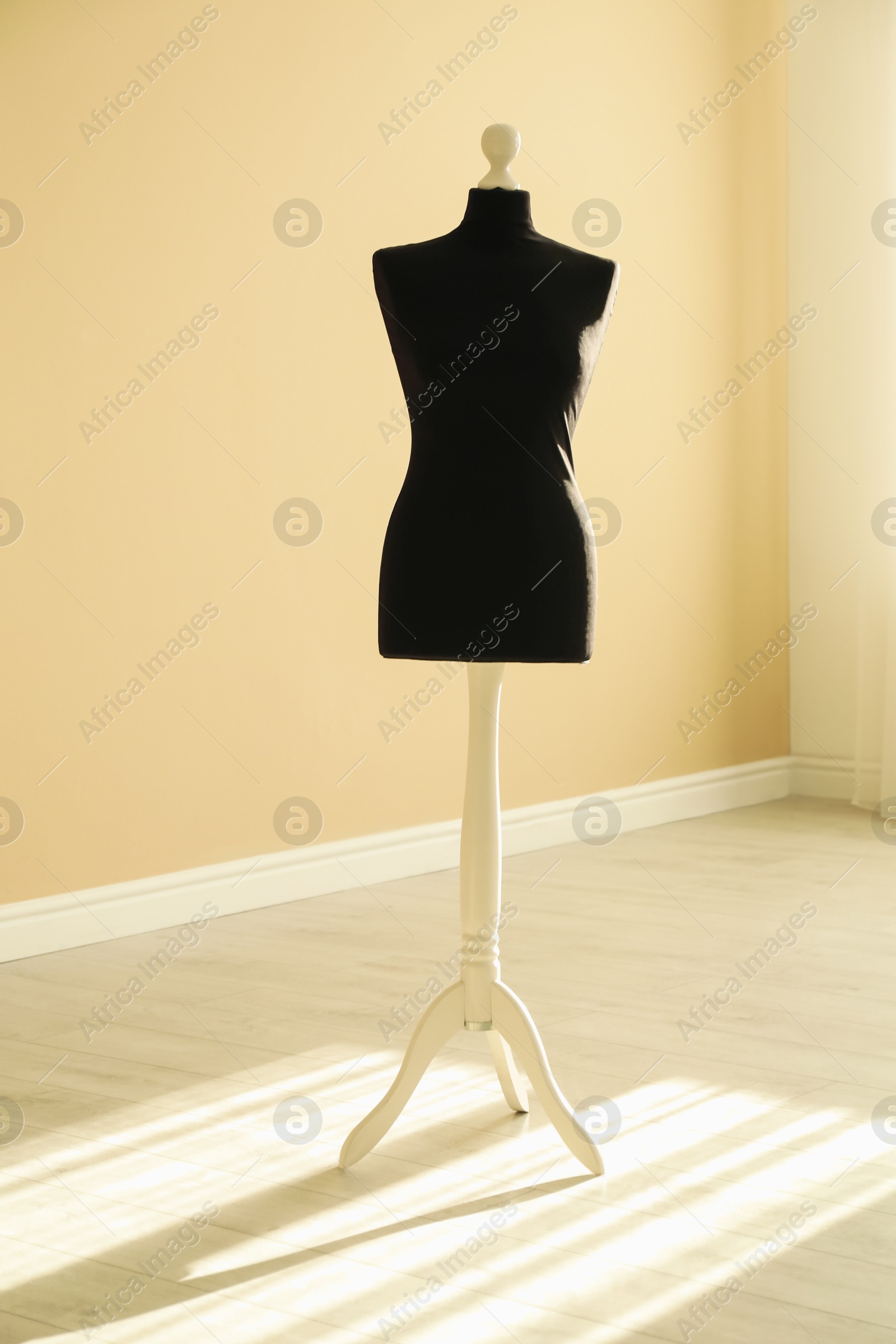 Photo of One black female mannequin near beige wall