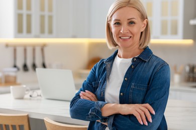 Happy middle aged woman in kitchen, space for text