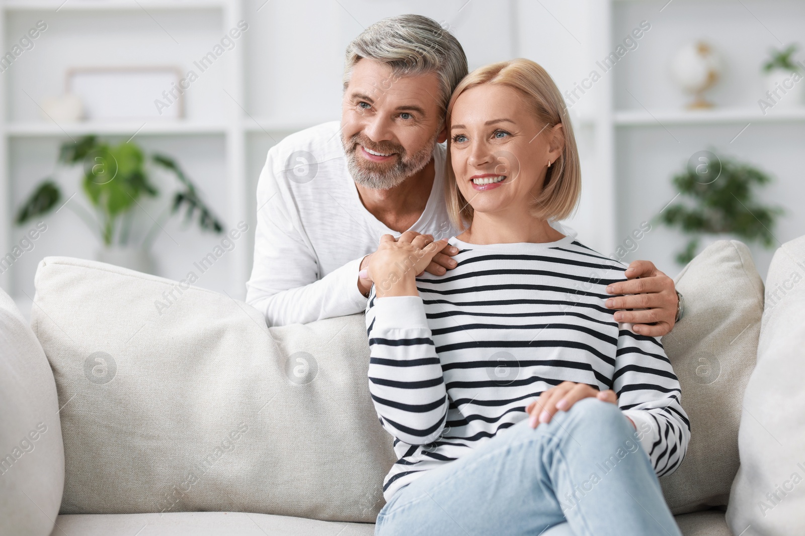 Photo of Happy middle aged couple in living room