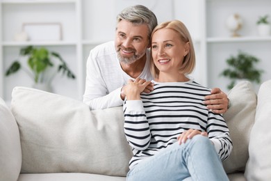 Photo of Happy middle aged couple in living room