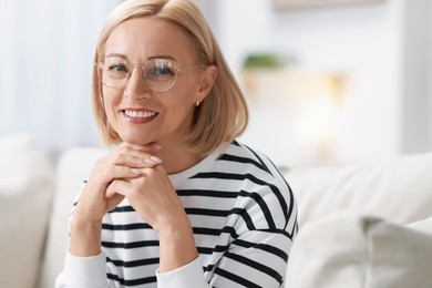 Portrait of happy middle aged woman in glasses indoors. Space for text