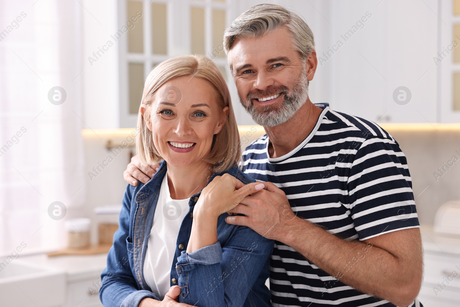 Photo of Portrait of happy middle aged couple in kitchen