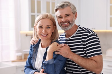 Portrait of happy middle aged couple in kitchen