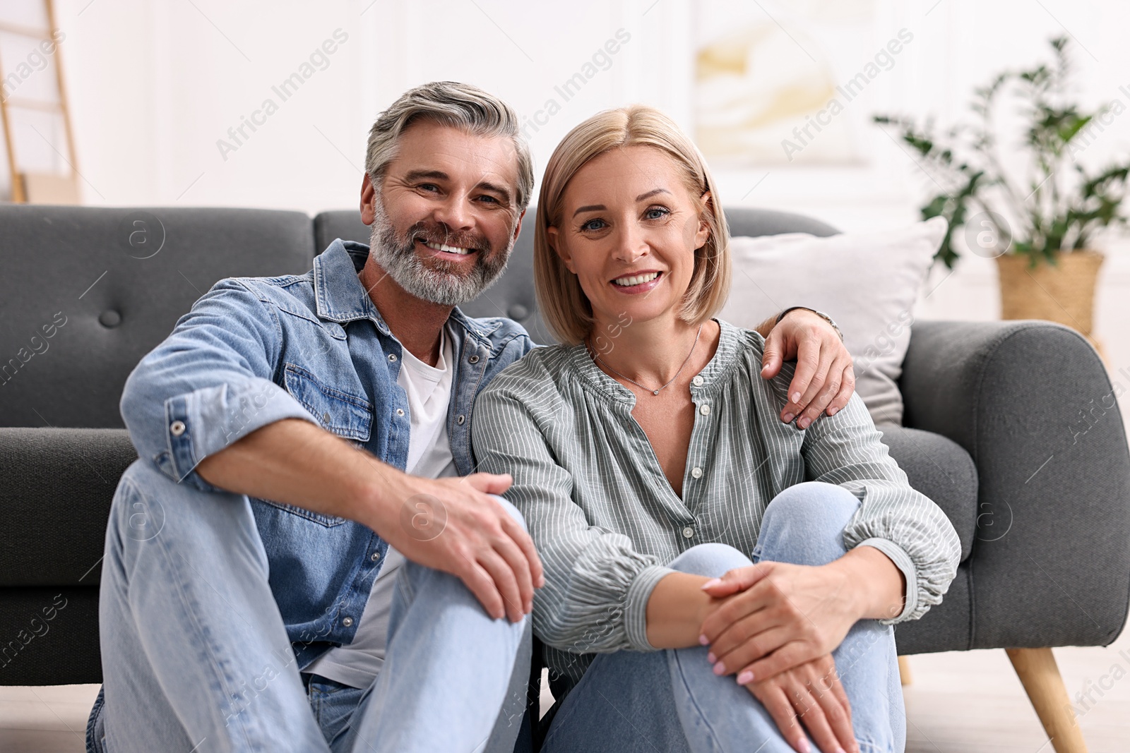 Photo of Portrait of happy middle aged couple on floor at home