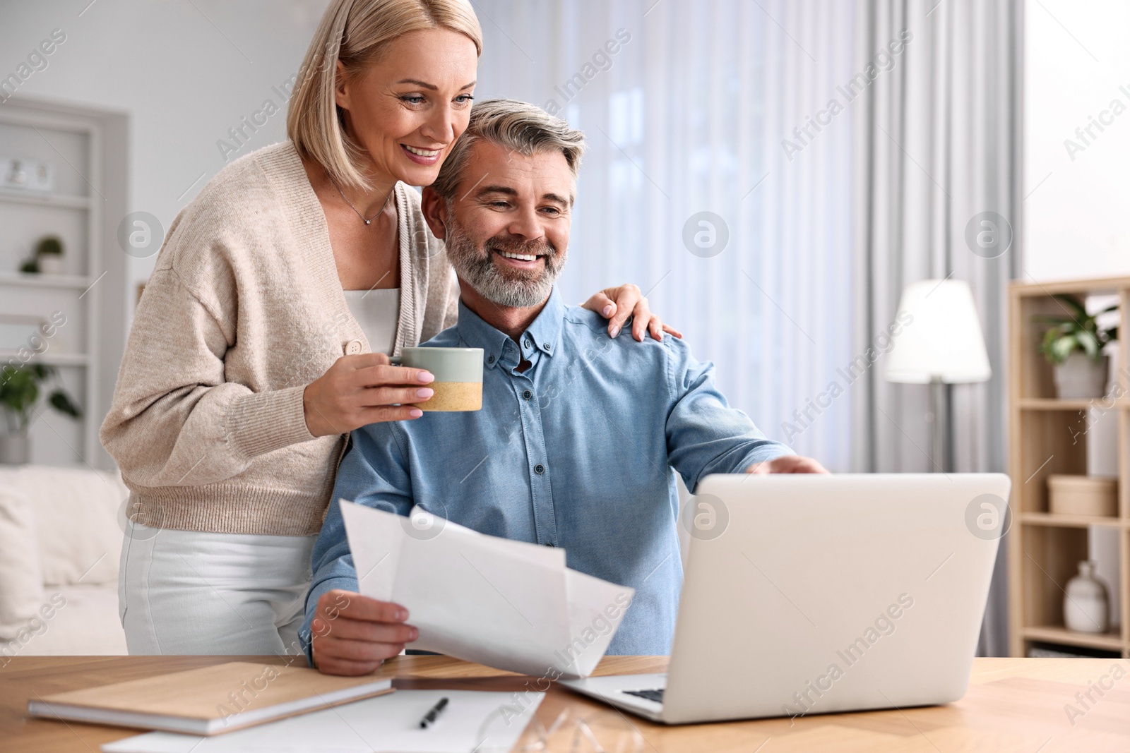 Photo of Happy middle aged couple working at home