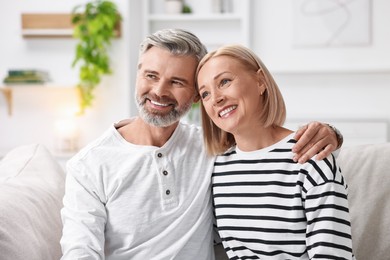 Happy middle aged couple on sofa at home