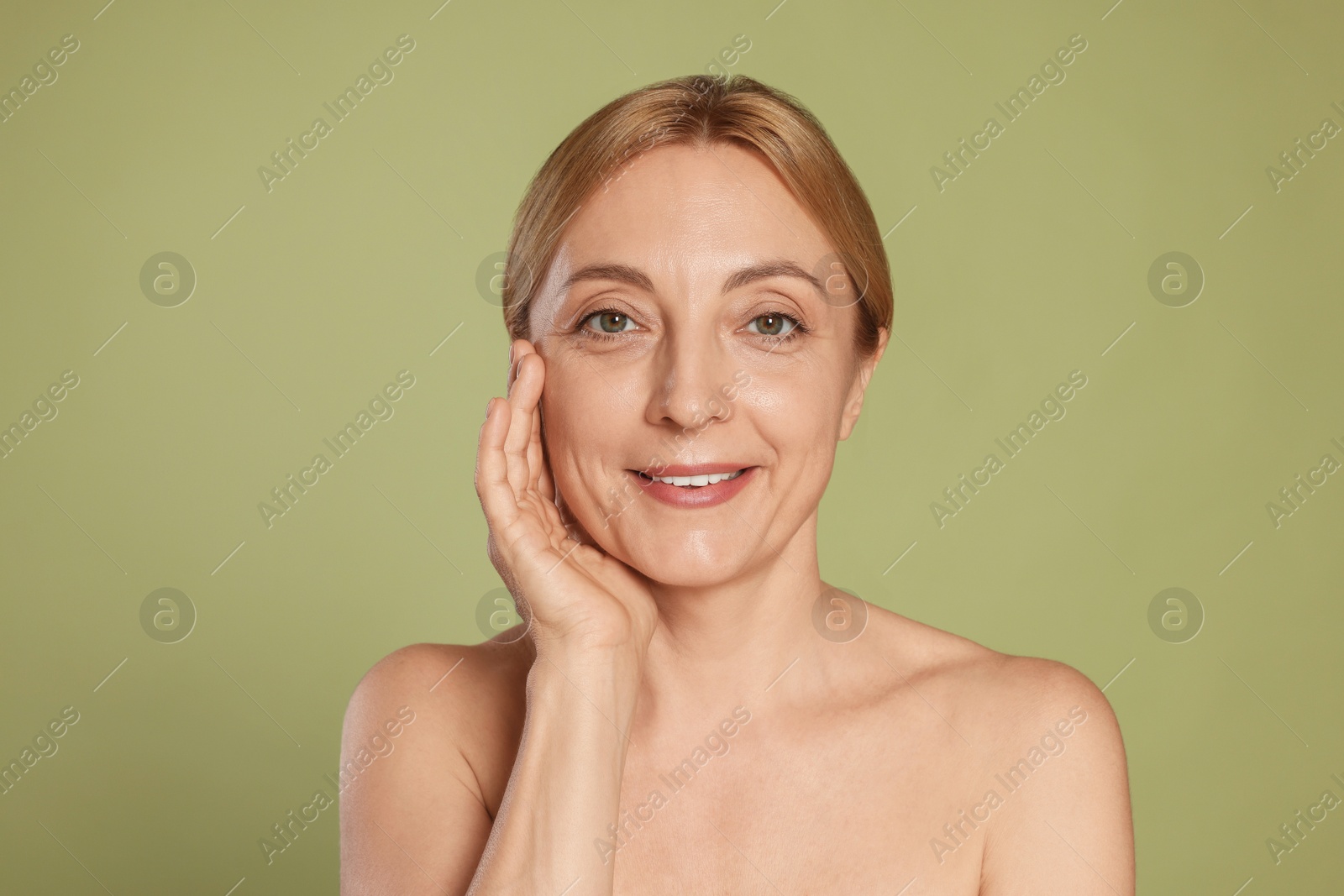 Photo of Portrait of smiling woman with healthy skin on green background