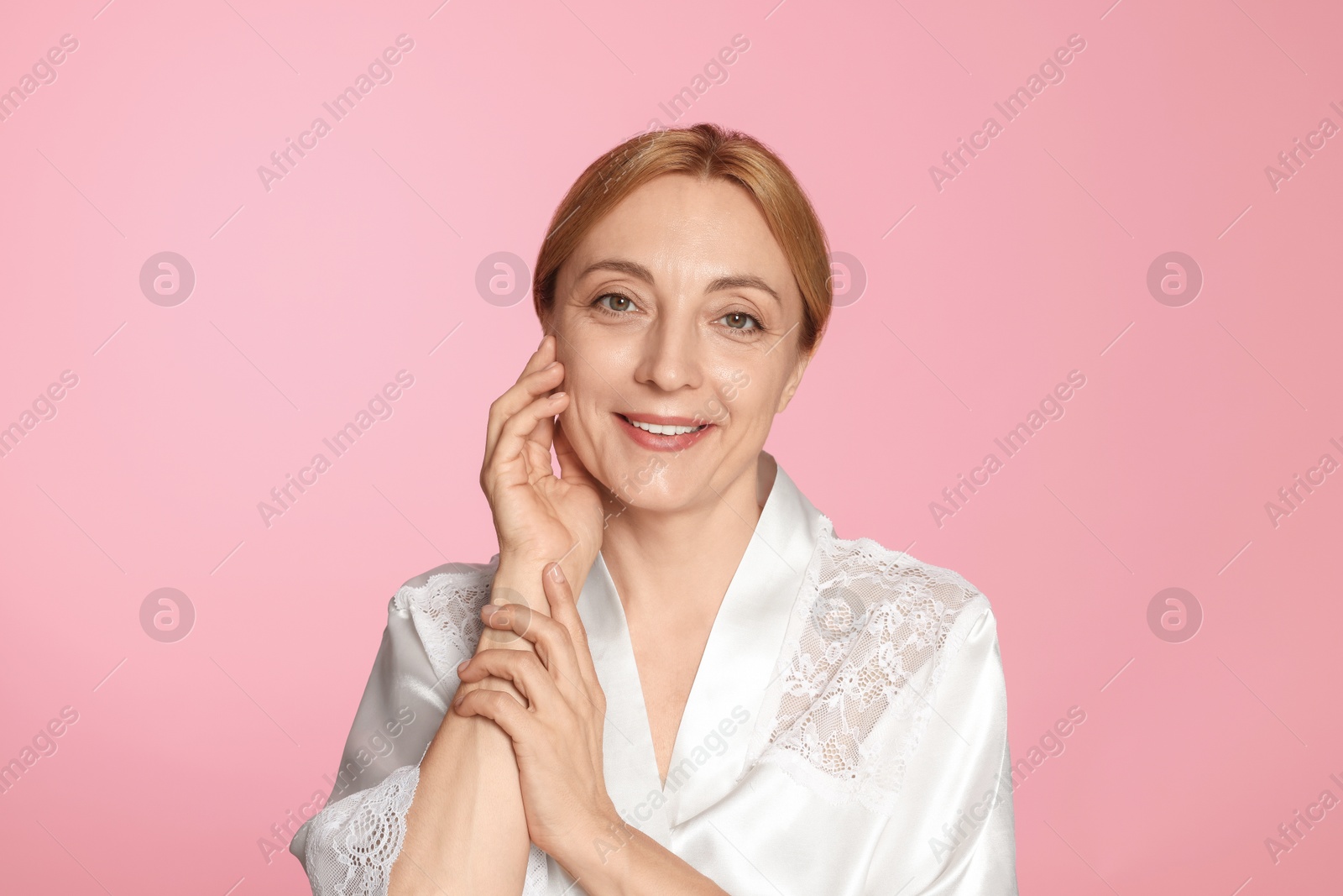 Photo of Portrait of smiling woman with healthy skin on pink background