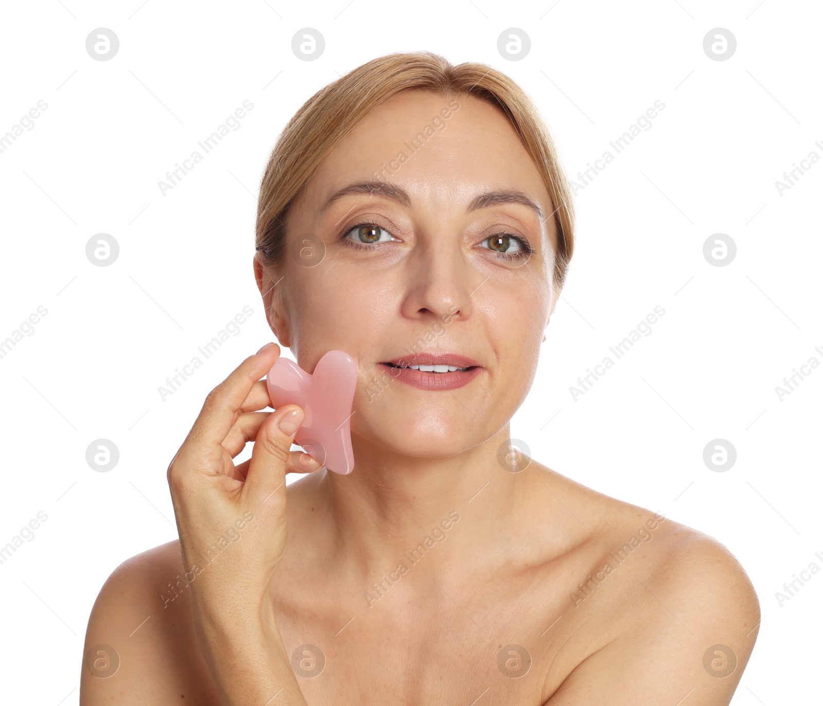 Photo of Smiling woman doing facial self massage with gua sha tool on white background