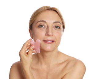 Smiling woman doing facial self massage with gua sha tool on white background