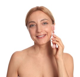 Smiling woman doing facial self massage with roller on white background