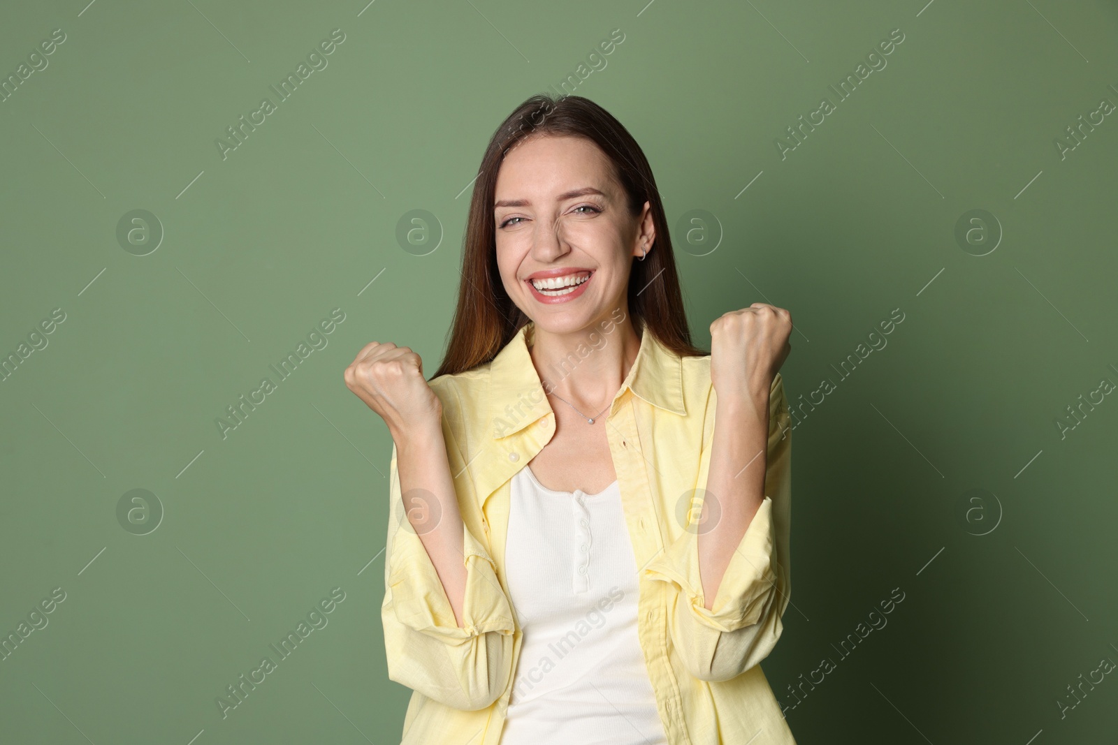 Photo of Portrait of happy winner on green background