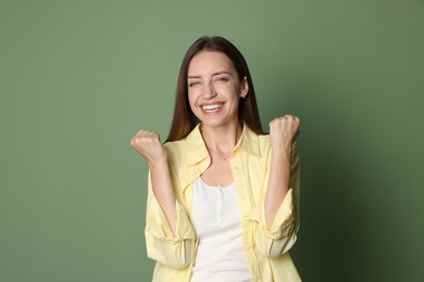 Portrait of happy winner on green background