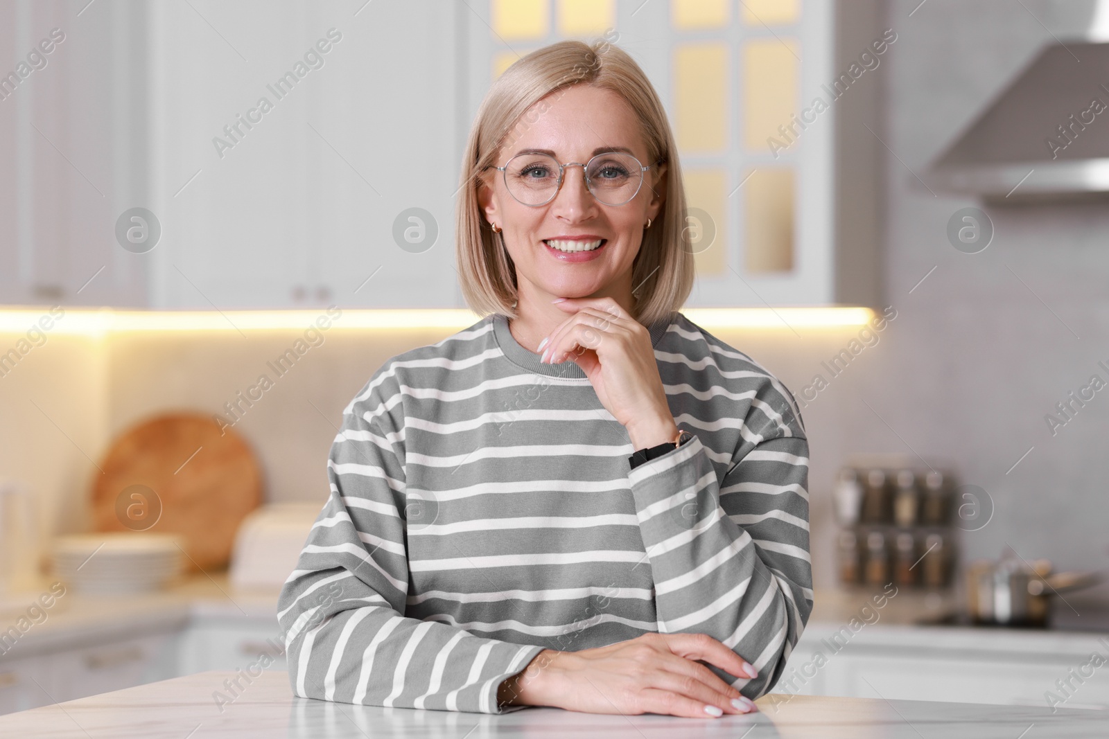 Photo of Portrait of smiling middle aged woman in kitchen