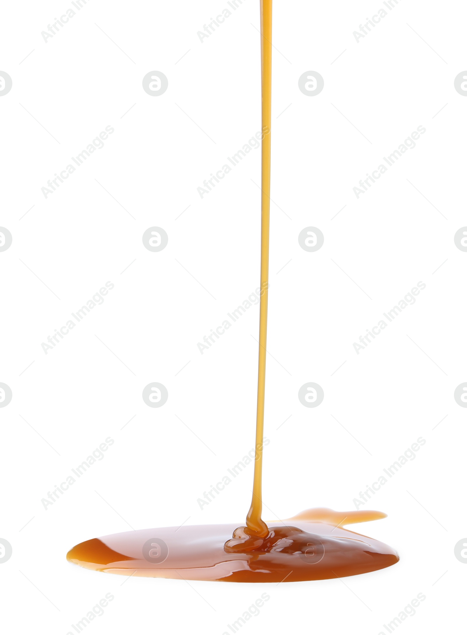 Photo of Tasty caramel sauce dripping on white background, closeup