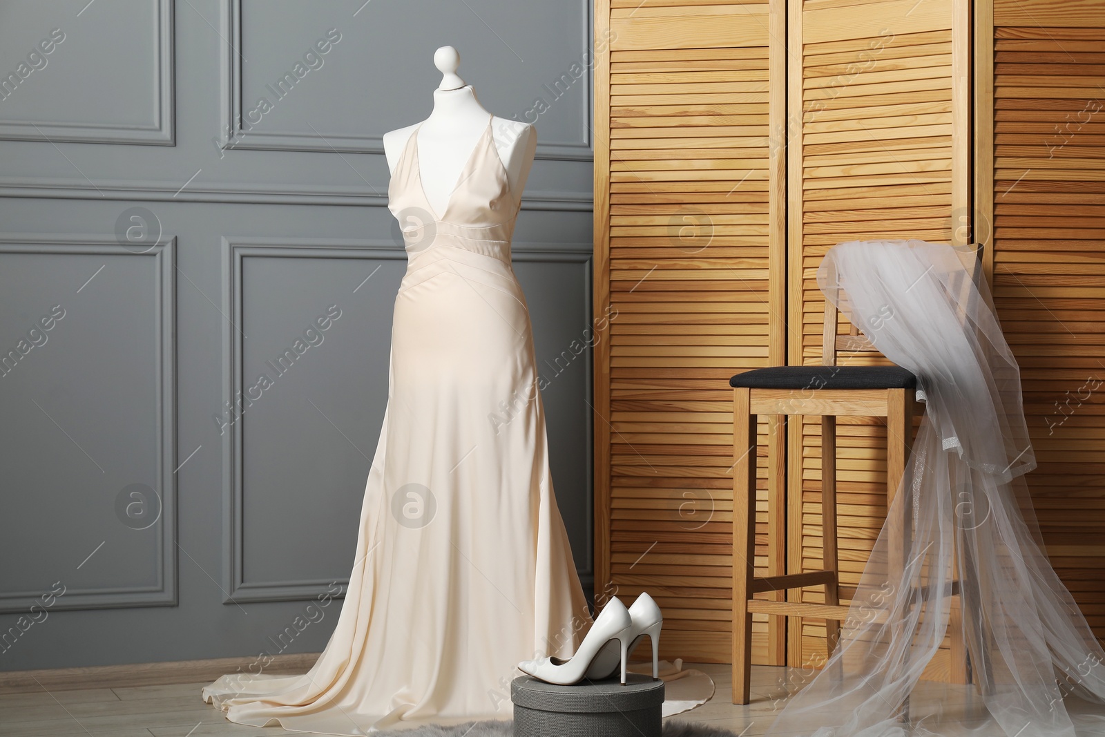 Photo of Beautiful wedding dress on mannequin, veil and shoes in boutique