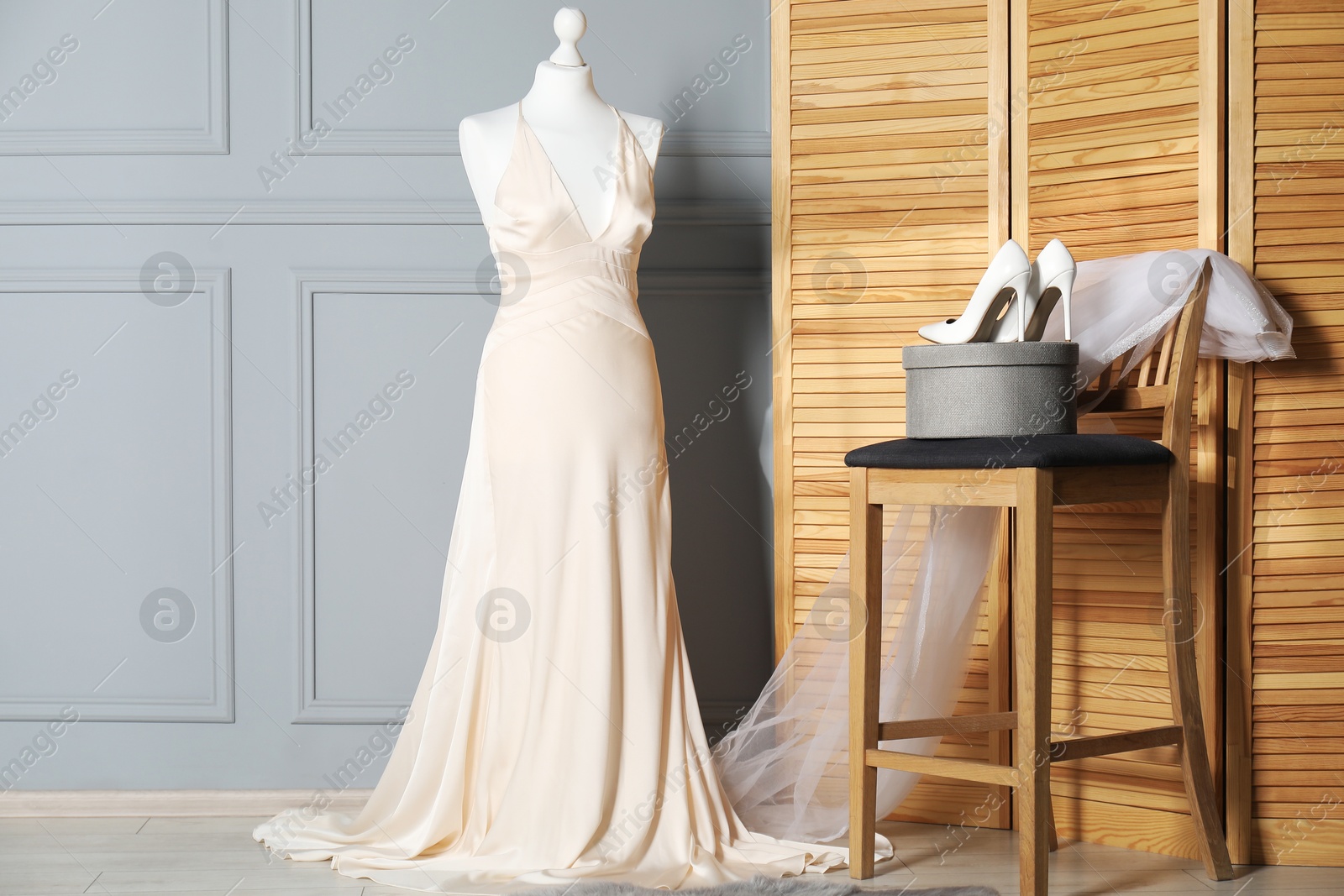 Photo of Beautiful wedding dress on mannequin, veil and shoes in boutique