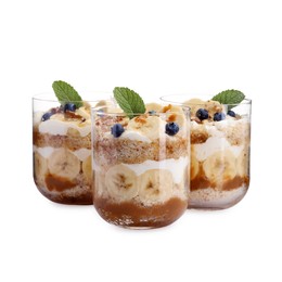 Photo of Tasty trifle dessert. Sponge cake, blueberries, banana and whipped cream in glasses isolated on white