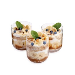 Photo of Tasty trifle dessert. Sponge cake, blueberries, banana and whipped cream in glasses isolated on white